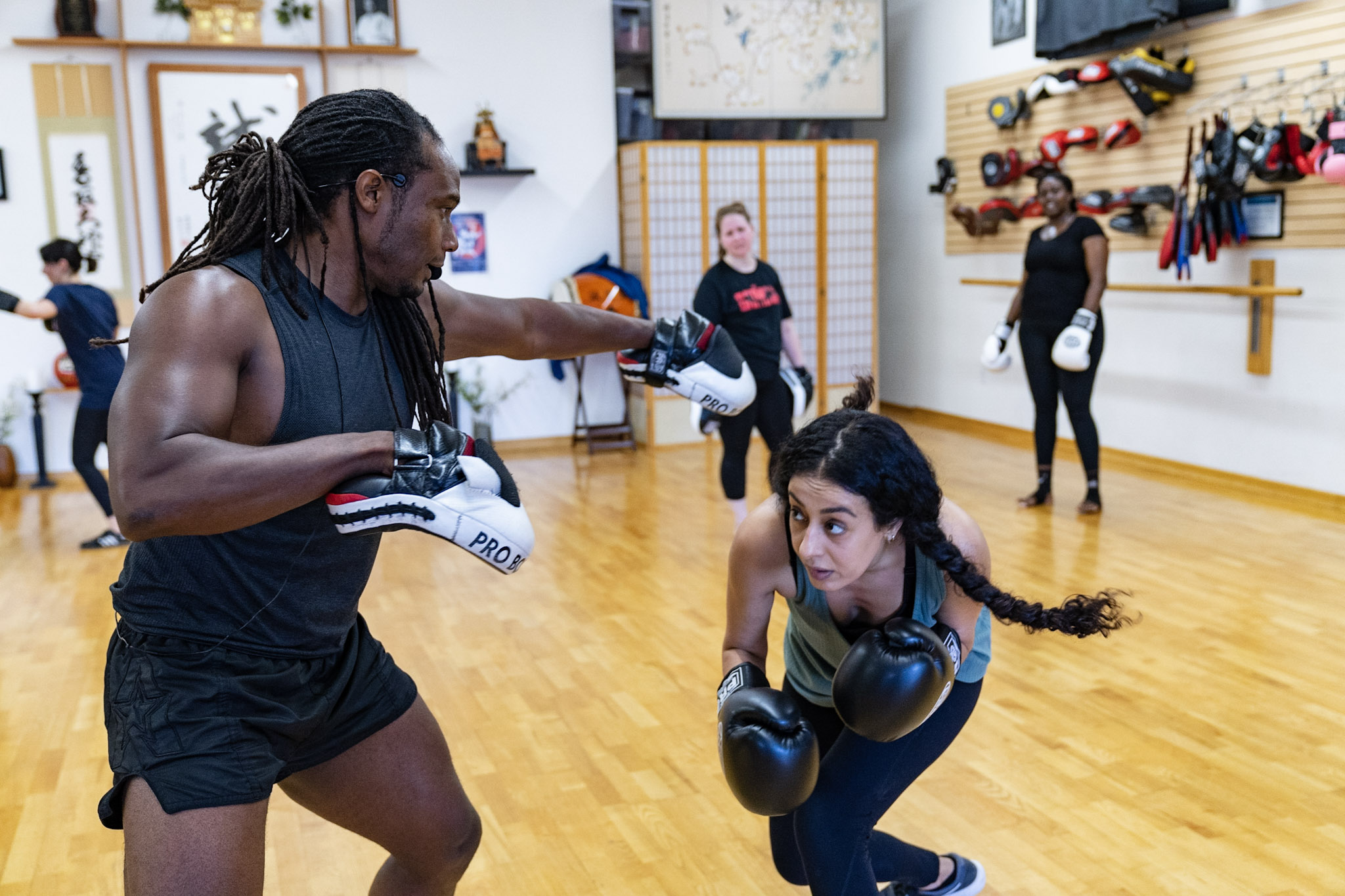 Trainer Rashad El Amin working with a student during kickboxing class